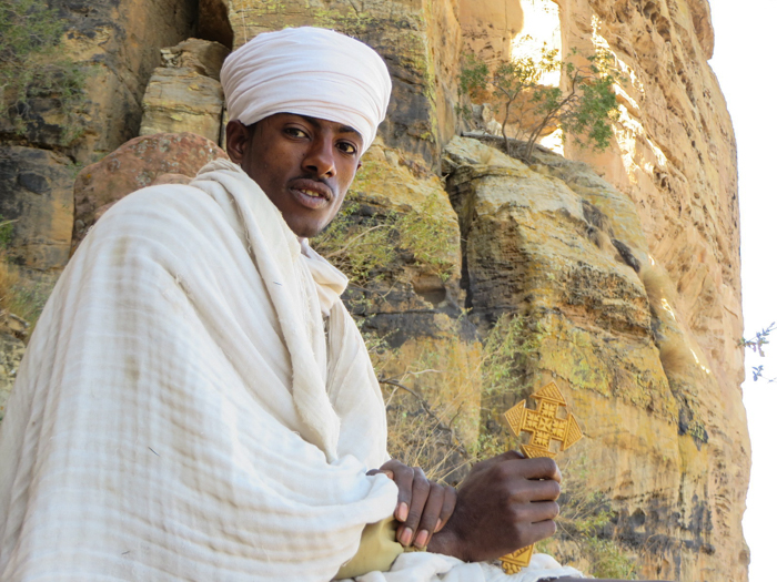 A priest at a rock carved church in the Tigrai Mountains, Ethiopia with GeoEx.