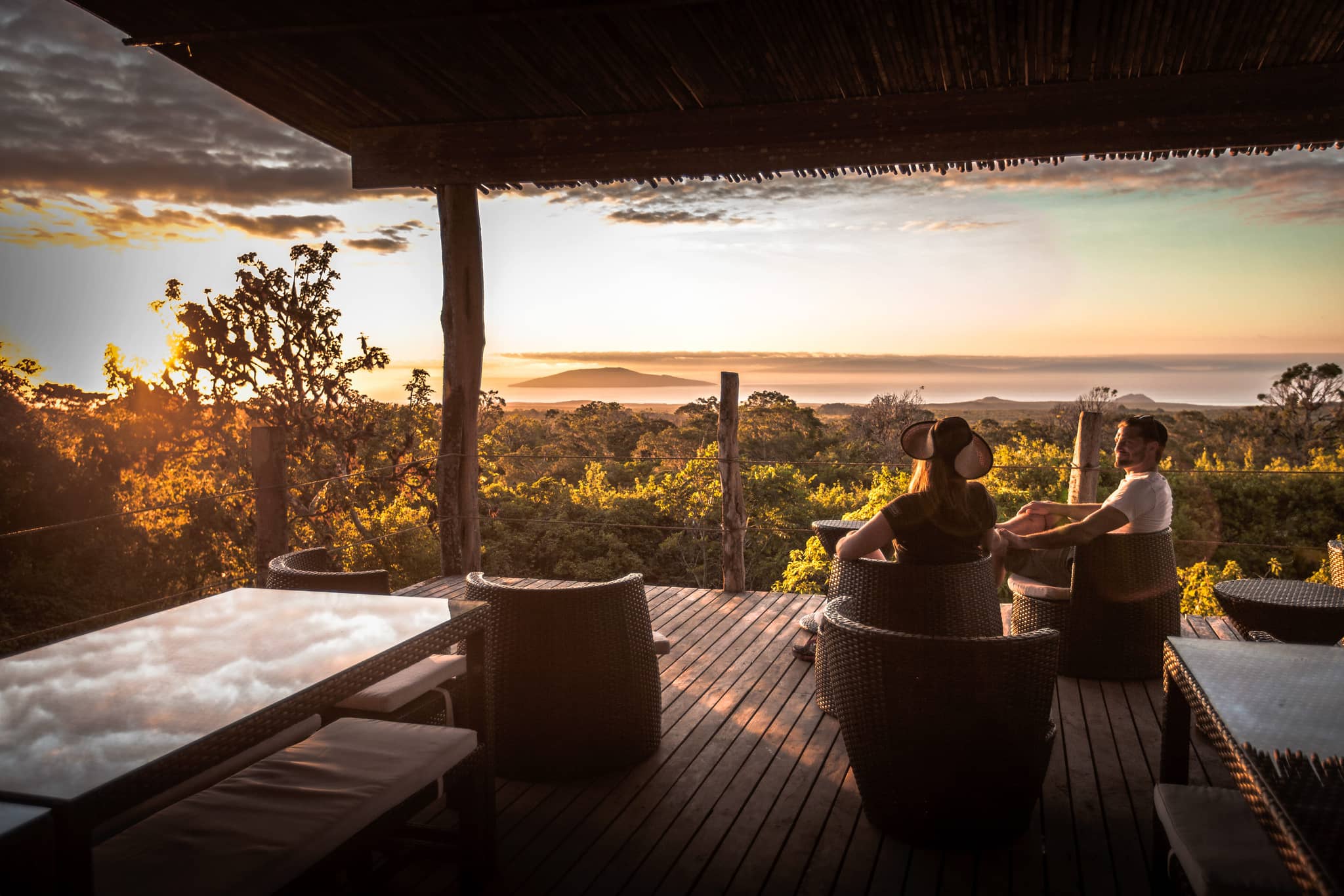 Couple at Galapagos Safari Camp balcony watching sunset