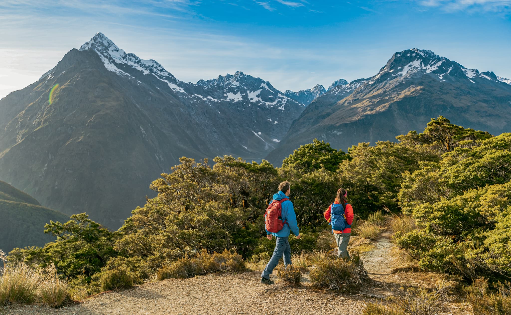 Hiking couple walking on trail at Routeburn Track in New Zealand
