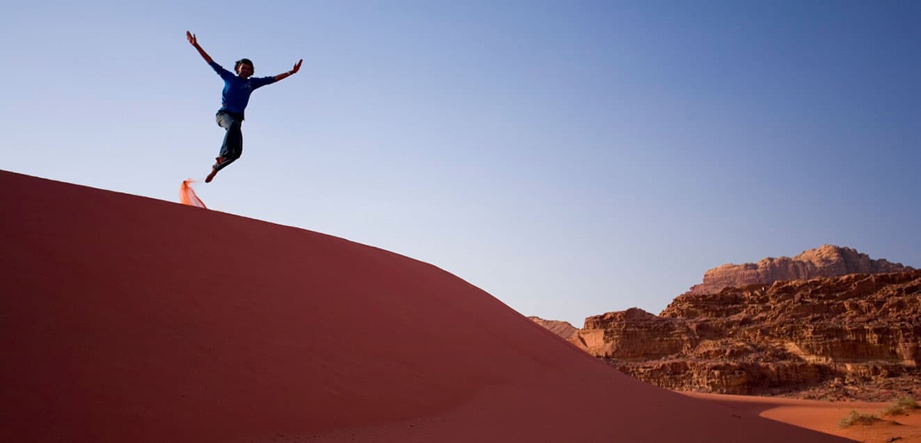 jordan person jumping in sand dunes