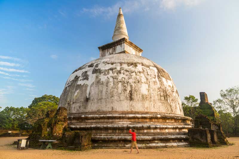 Man walking around stupa in the ancient city of Polonnaruwa, Sri Lanka with GeoEx