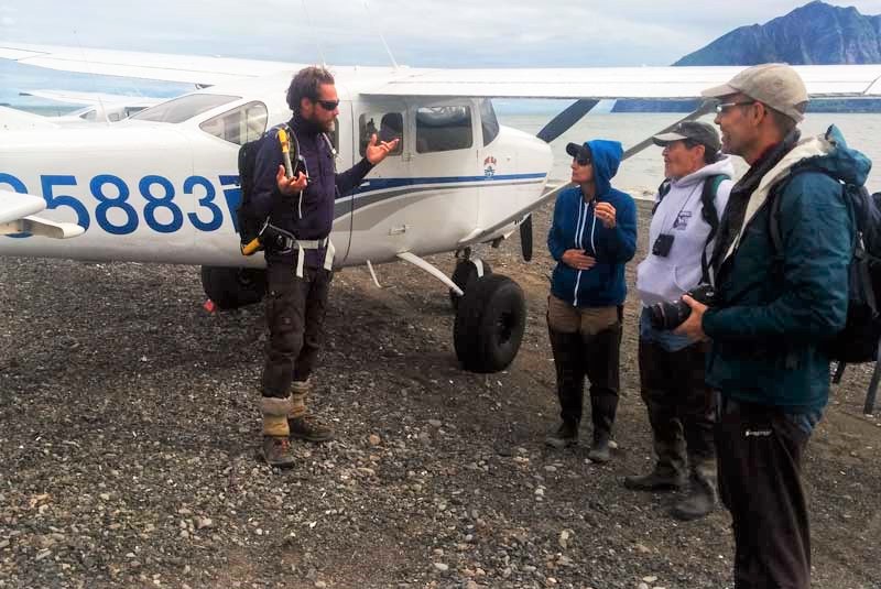 Alaska travelers and bear-watching guide near their plane 