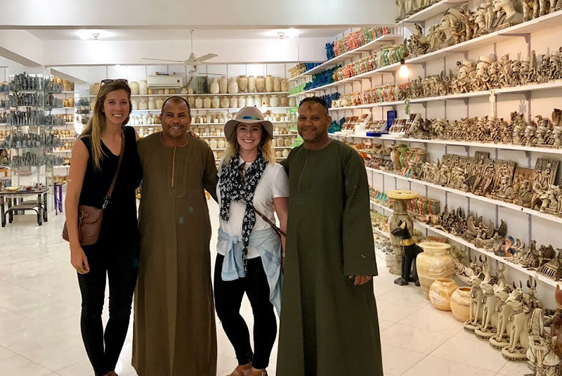 Travelers with shopkeepers in alabaster store, Luxor, Egypt