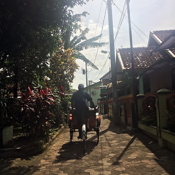 Riding a bicycle tuk-tuk through a neighborhood in Yogyakarta, Indonesia