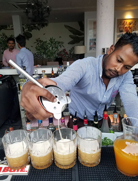 A man pours a Sri Lankan liquor, called arrack, made from coconut flowers