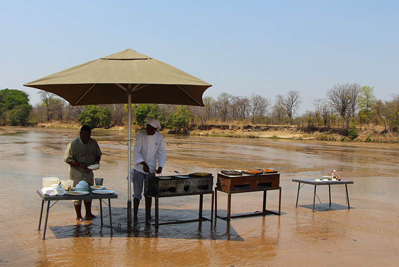 Setting up for a surprise lunch during a Zambia safari.