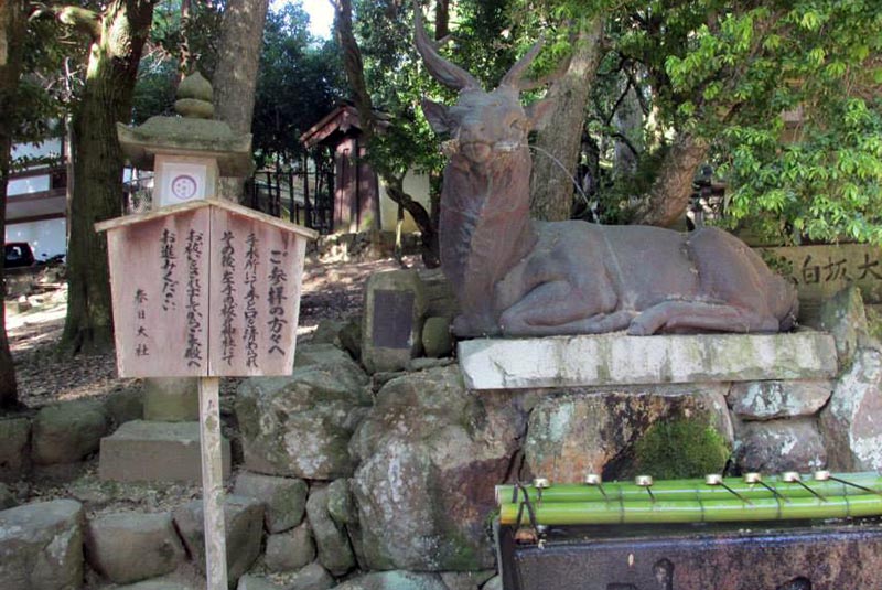 Deer statue at fountain for ritual washing  by temple of Nara, Japan