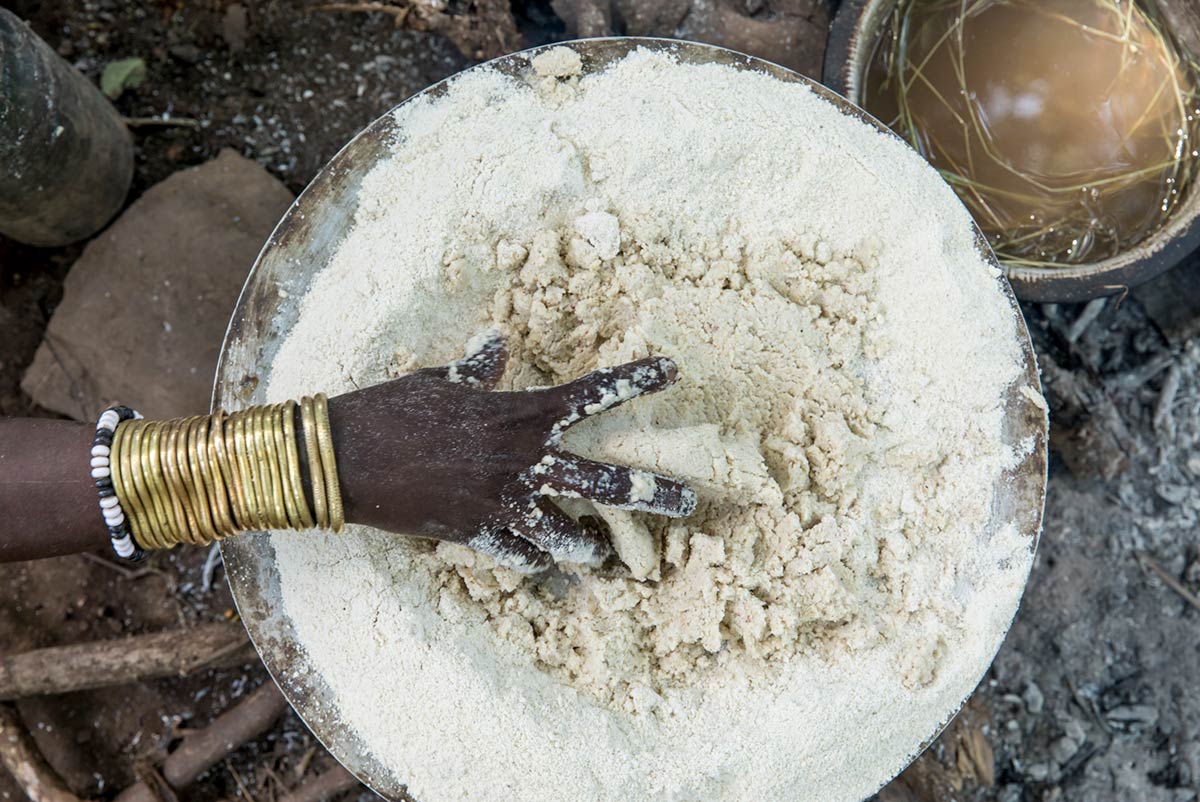 Mursi woman preparing dough, Omo Valley, Ethiopia