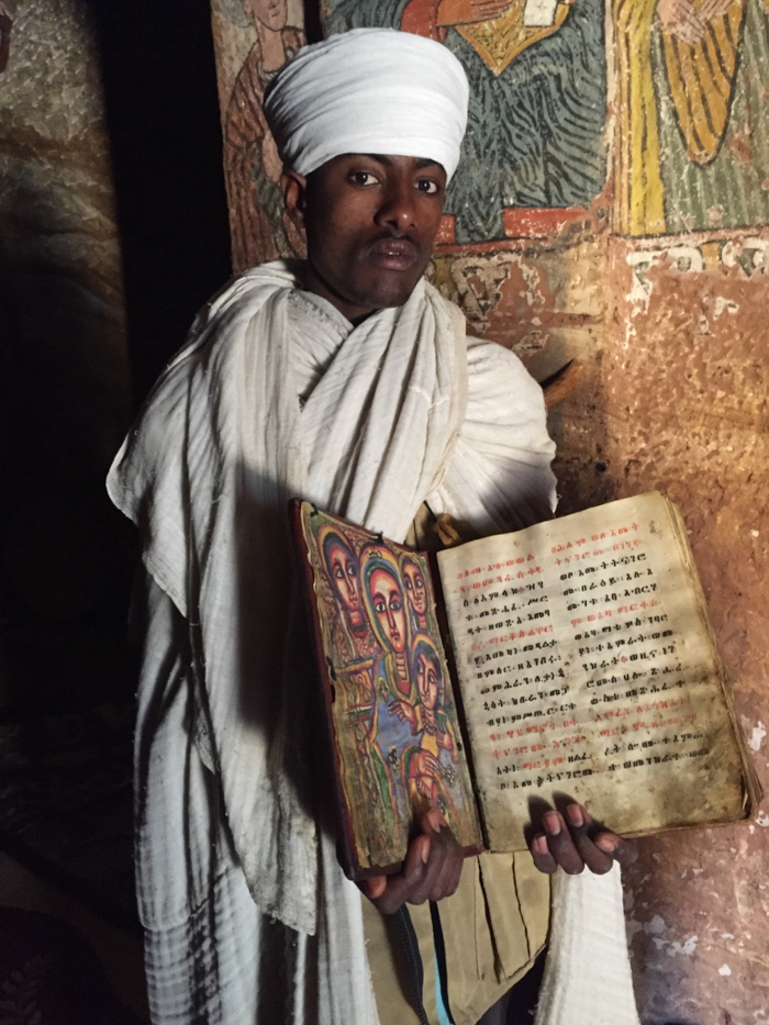 A priest shows his manuscripts in the Tigrai Mountains, Ethiopia with GeoEx.