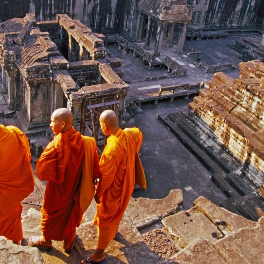 Three monks overlook Angkor Wat, Cambodia with GeoEx