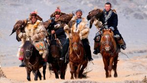 Eagle hunters riding horses to the Eagle Hunters festival in Mongolia.