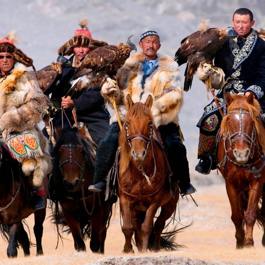 Eagle hunters riding horses to the Eagle Hunters festival in Mongolia.