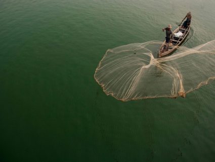Fisherman casting net on Irrawaddy River, Mandalay, Myanmar with GeoEx
