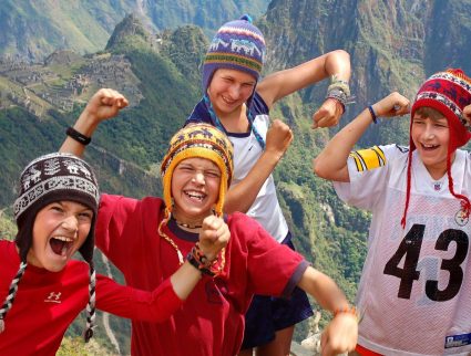 Kids in front of peaks and ruins in the Sacred Valley, Peru