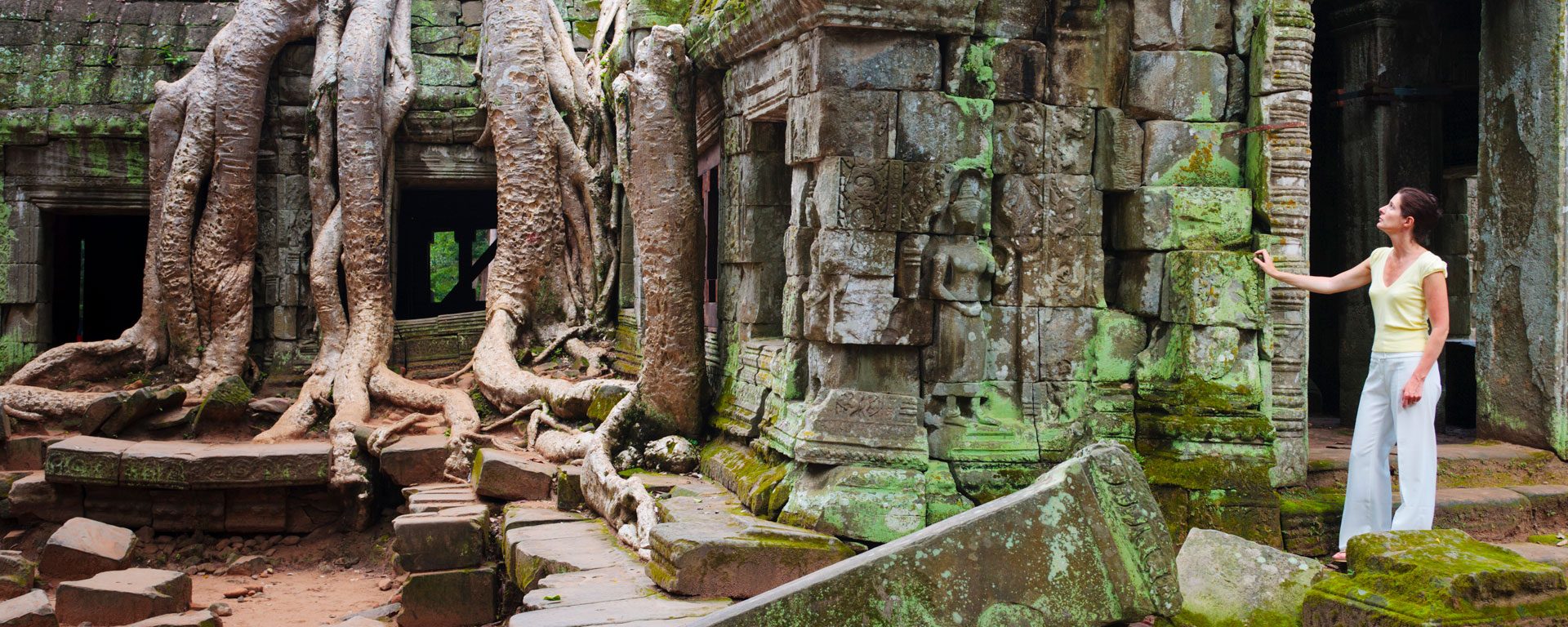 Woman exploring Ta Phrom Temple in Angkor, Cambodia