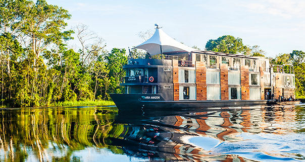 The Aqua Expeditions Aria riverboat navigates a waterway in the Amazon, Peru