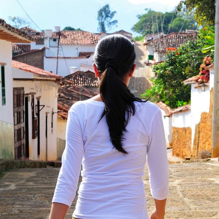 Woman walking down a street in the colonial town of Barichara, Colombia, South America.