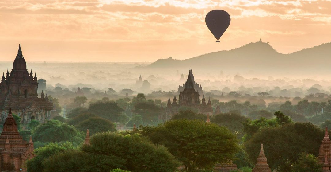 Hot air balloon flies over temples at dawn, Bagan, Myanmar