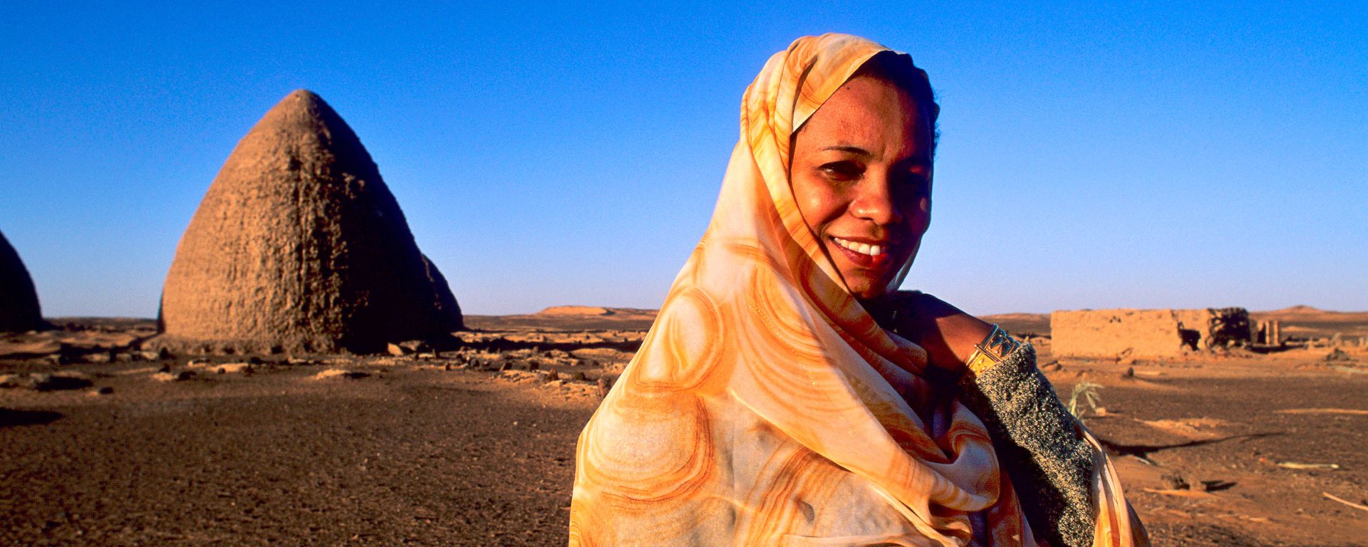 Nubian woman in front of domed structures in Old Dongola, Sudan