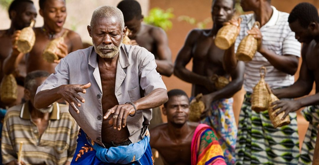 Village elder dancing with drummers during voodoo ceremony in Atitogan, Togo