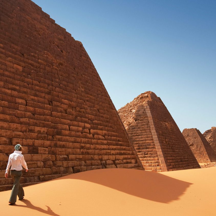 A woman explores the ancient Nubian pyramids of Begrawiya, Sudan