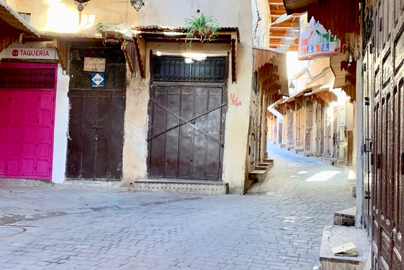 An empty town square and alleyway in Fez, Morocco, early morning.