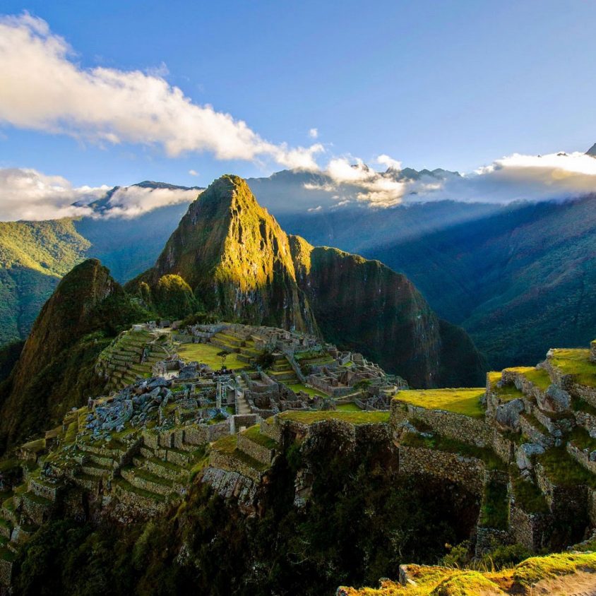 The suns rays shine on the Incan site of Machu Picchu, Peru