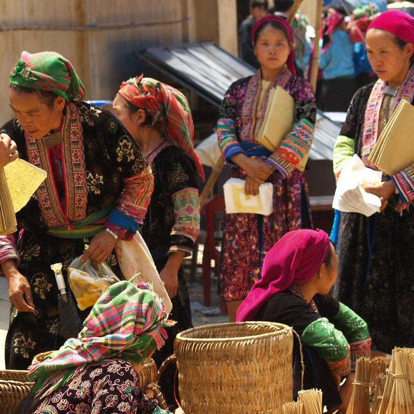 Women in tribal dress gather at a market in Ha Giang Province, Vietnam