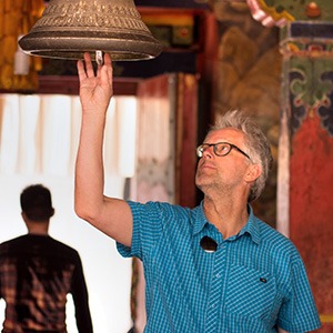 GeoEx trek leader Bart Jordans ringing a bell in Tibet