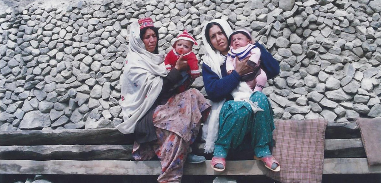 Two women with twin babies outside a home in Hunza, Pakistan
