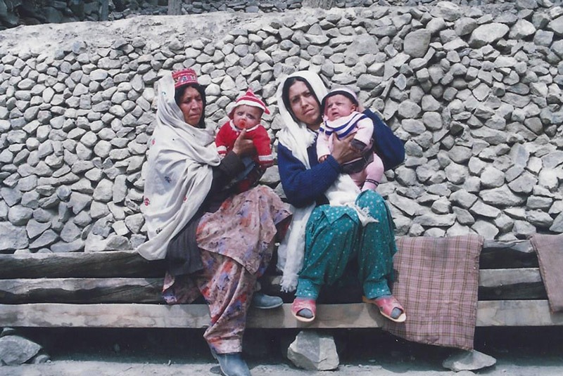 Two women with twin babies outside a home in Hunza, Pakistan