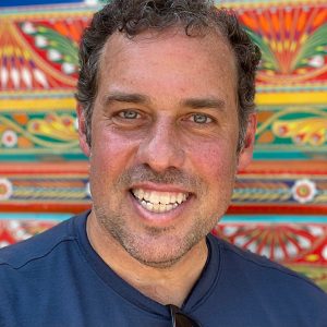 GeoEx CEO Brady Binstadt in front of a colorful jingle truck in Pakistan