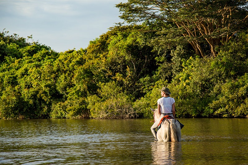 Woman riding horse at Corocora Camp, Colombia