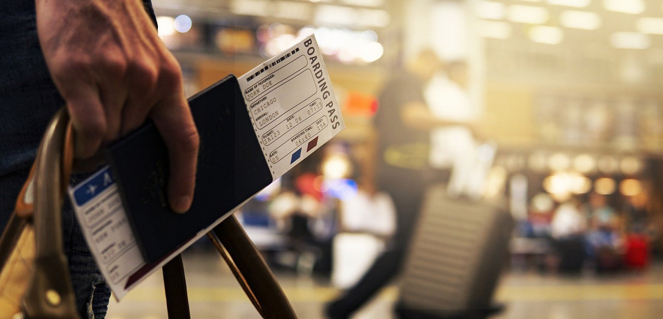 Man walking through airport with passport and boarding pass in hand