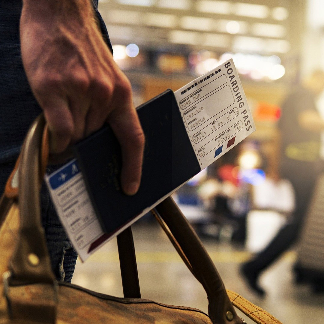 Man walking through airport with passport and boarding pass in hand