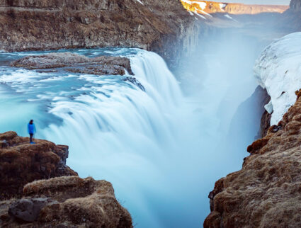 A hiker overlooks the rushing waters of Gullfoss, Iceland