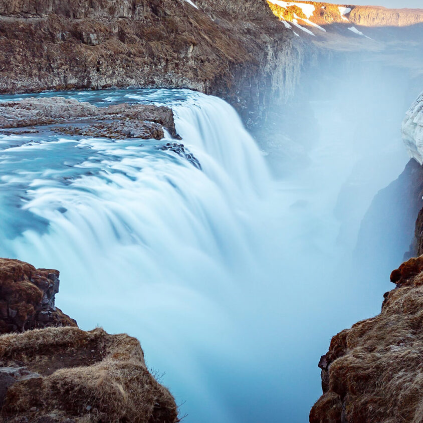 A hiker overlooks the rushing waters of Gullfoss, Iceland