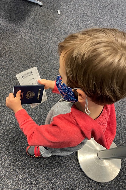 Alex's son holding his passport and boarding pass en route to Guatemala