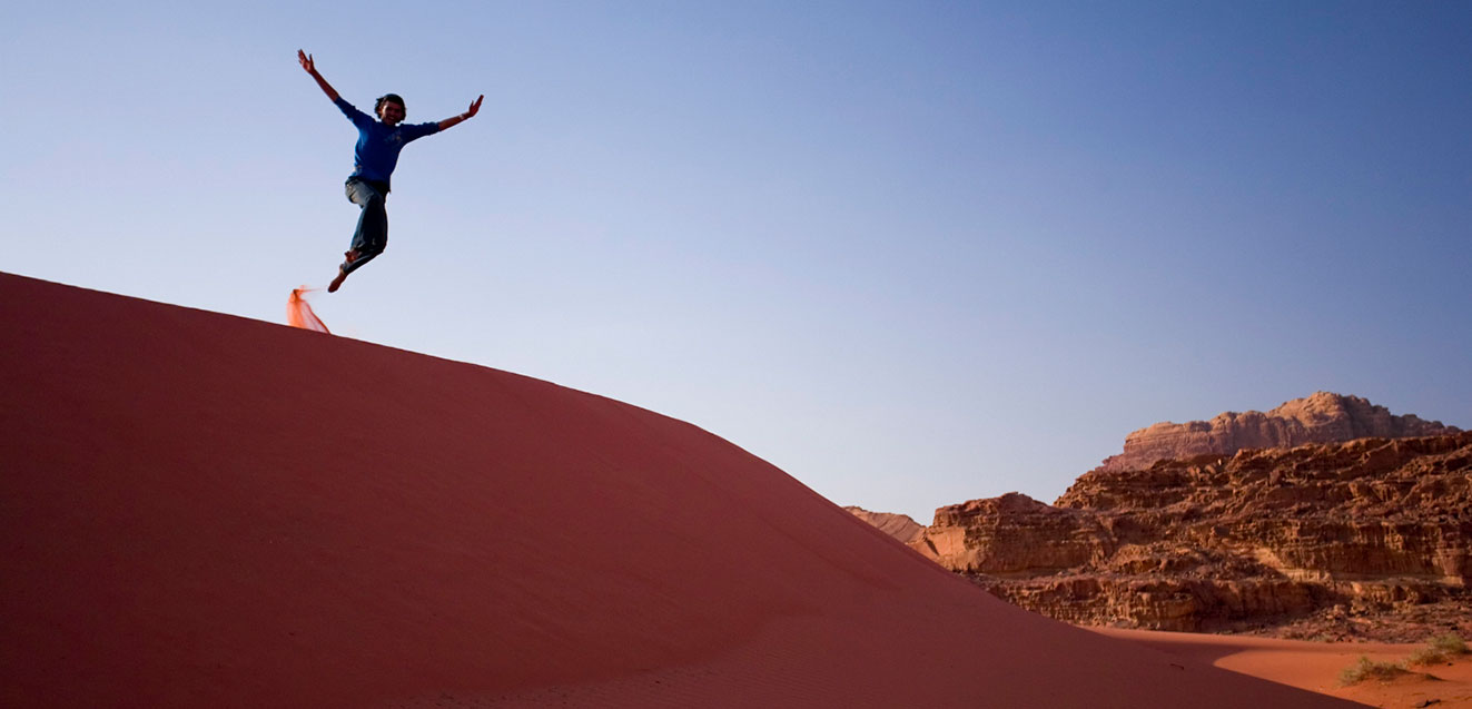 sliding down sand dunes in Jordan