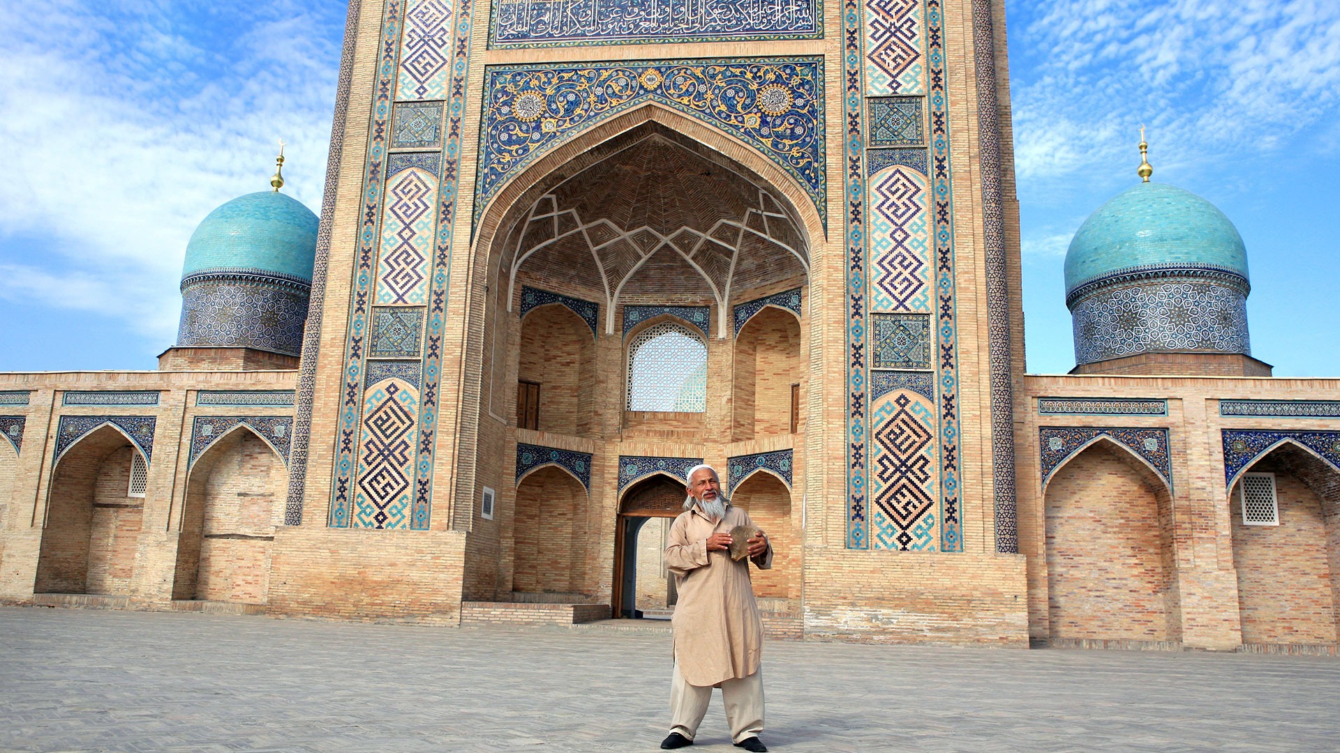 Uzbek man singing and dancing in front of mosque in Uzbekistan